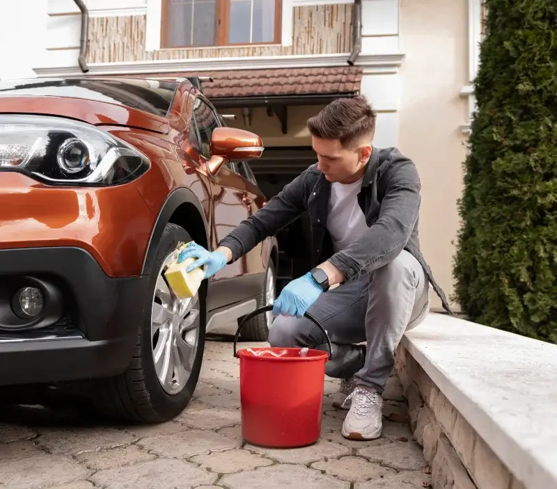 Lavage auto à domicile Genêts : professionnel intervenant sur un véhicule